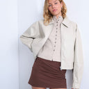 Topshop kurze, ecrufarbene Jacke aus Kunstleder mit überschnittenen Schultern und durchgehendem Reißverschluss.